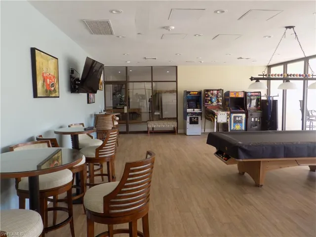 Rec room with wood finished floors, floor to ceiling windows, and billiards