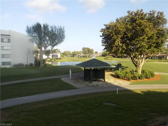 View of property's community featuring a lawn and a water view