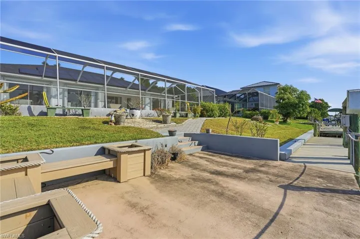 View of home's community with a sunroom, a residential view, a lawn, and a patio area