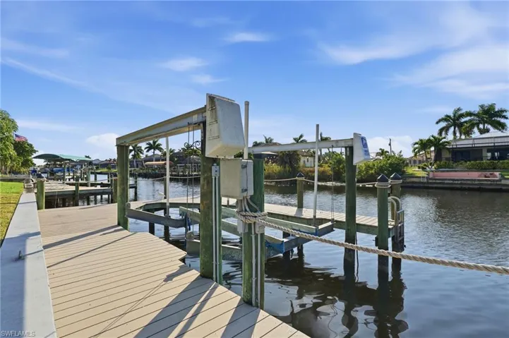 Dock featuring boat lift and a water view