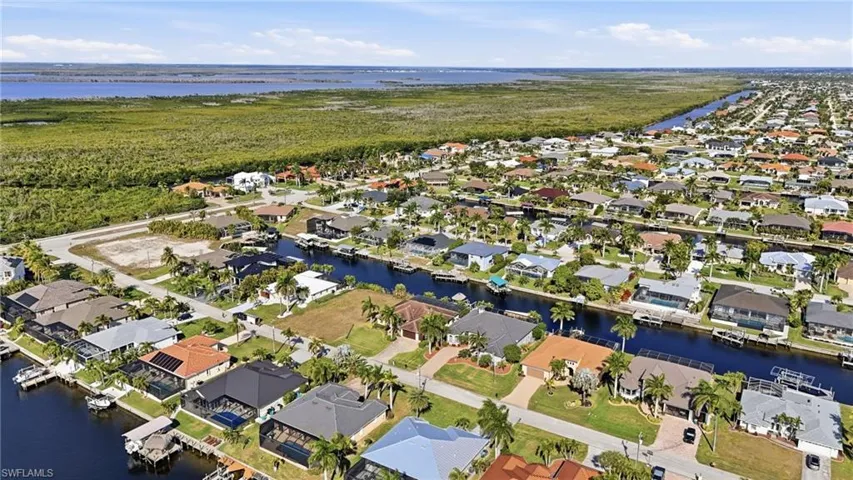 Aerial overview of property's location featuring a large body of water and nearby suburban area
