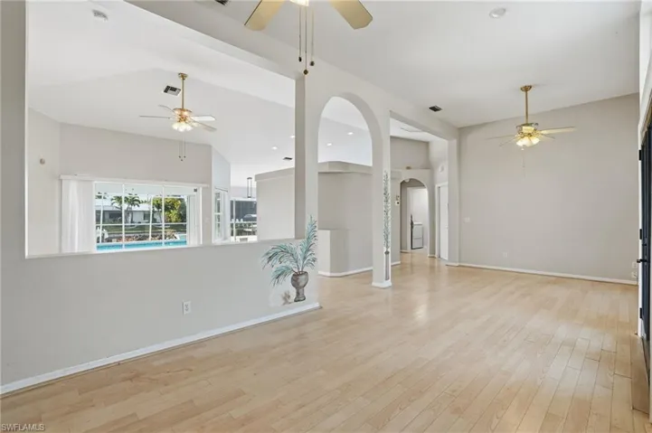 Spare room featuring a ceiling fan, arched walkways, light wood-type flooring, and recessed lighting