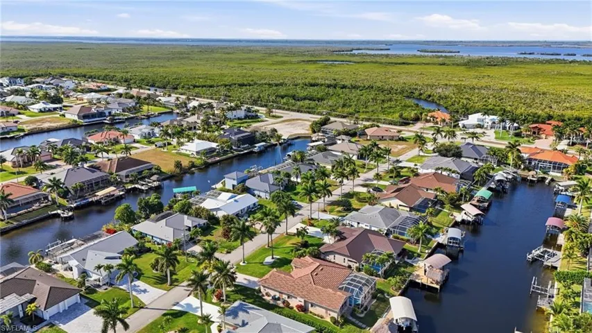 Aerial view of property and surrounding area with a nearby body of water and nearby suburban area