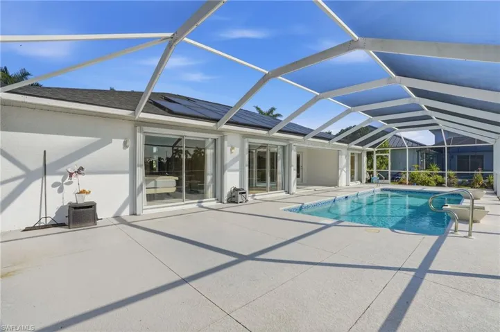 Swimming pool with a sunroom, a lanai, and a patio area