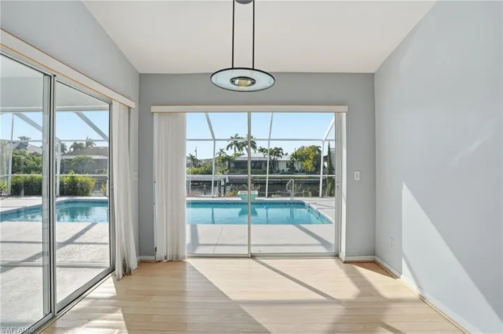 Doorway to outside with a sunroom, plenty of natural light, and hardwood / wood-style flooring