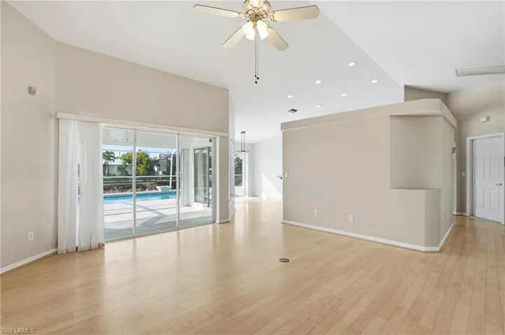 Spare room featuring ceiling fan, light wood-type flooring, recessed lighting, and vaulted ceiling