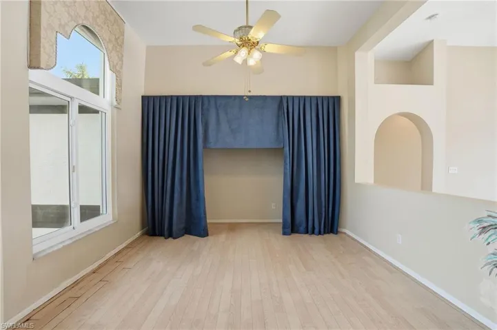 Empty room with light wood-style floors and ceiling fan