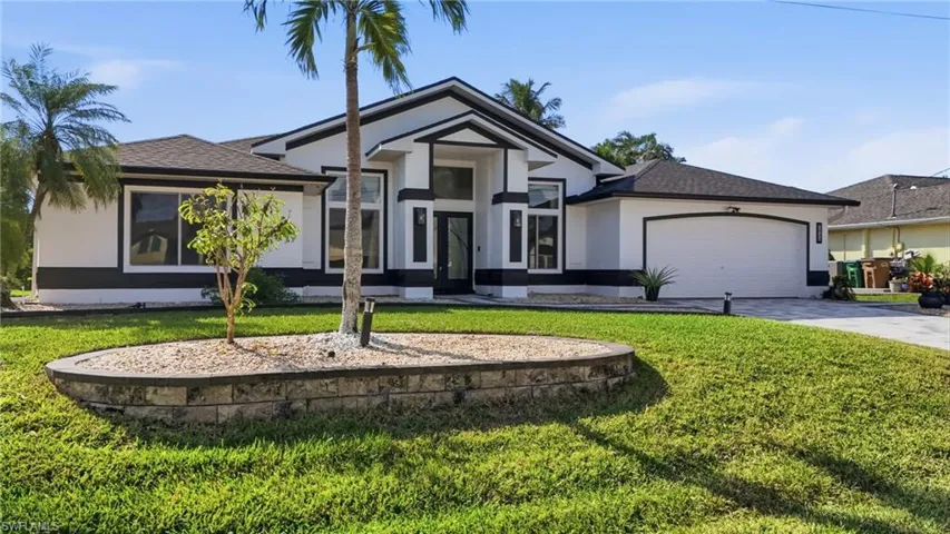 View of front of home featuring stucco siding, driveway, a front yard, and a shingled roof