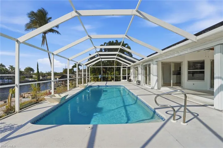 Outdoor pool featuring a sunroom, a patio, and a lanai