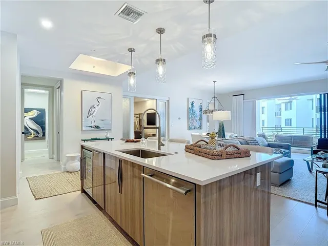 Kitchen featuring dishwasher, a kitchen island with sink, light hardwood / wood-style flooring, sink, and decorative light fixtures