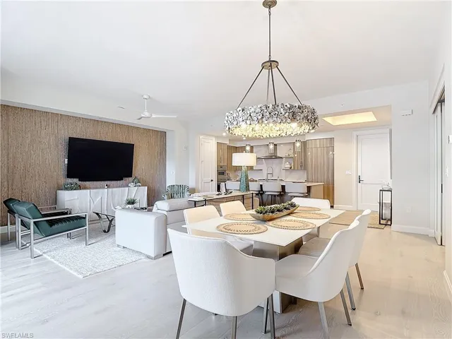 Dining room featuring light hardwood / wood-style flooring, sink, and ceiling fan with notable chandelier
