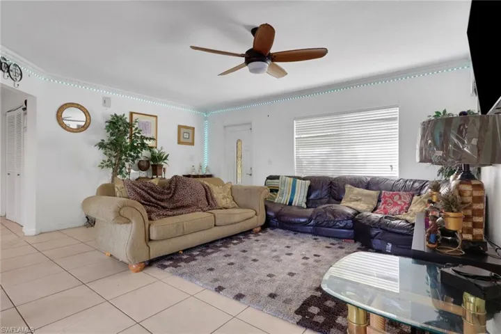 Living room featuring light tile patterned flooring and a ceiling fan