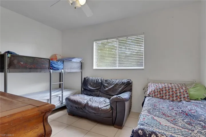Bedroom with ceiling fan and light tile patterned floors