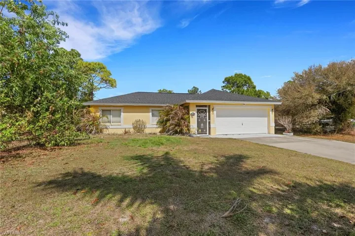 Single story home with a front yard, concrete driveway, a garage, and stucco siding