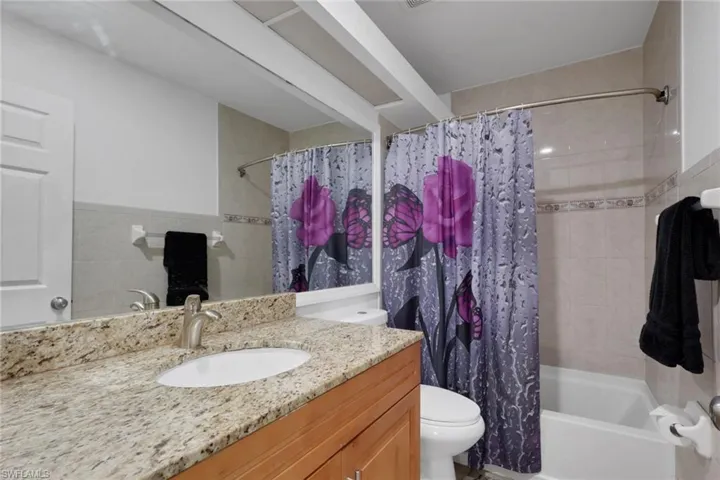 Bathroom featuring vanity and shower / bath combo with shower curtain