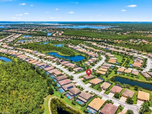 Aerial perspective showcasing a residential community with individual properties, winding streets, and multiple water features