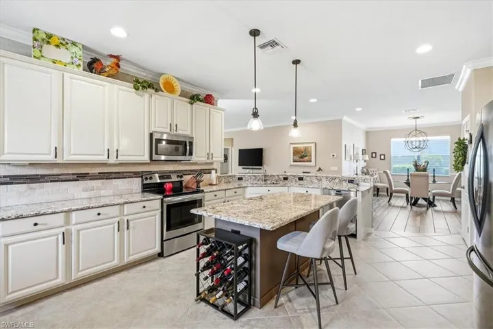 Kitchen featuring white cabinetry, stainless steel appliances, a tile backsplash, and light-toned countertops