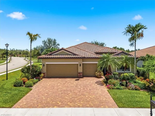 Mediterranean-style residence featuring a tile roof and a paver driveway