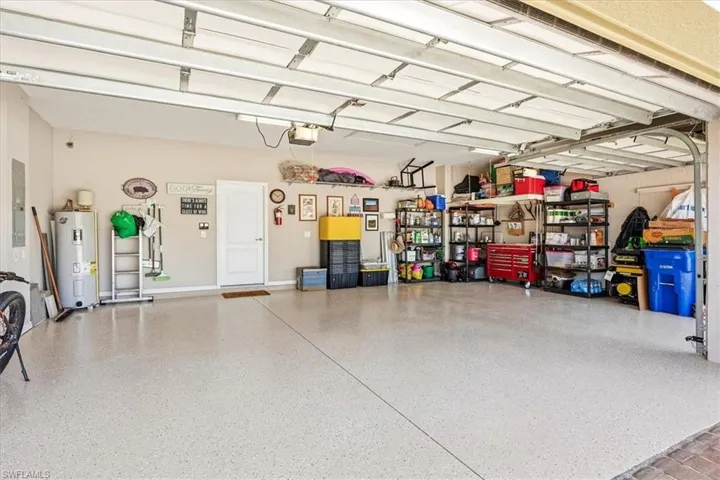 Spacious garage featuring a light-toned epoxy floor, multiple overhead garage doors, and ample wall space