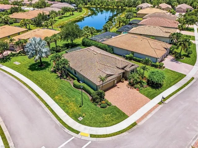 Single-story residence featuring a tile roof, paver driveway, and manicured landscaping