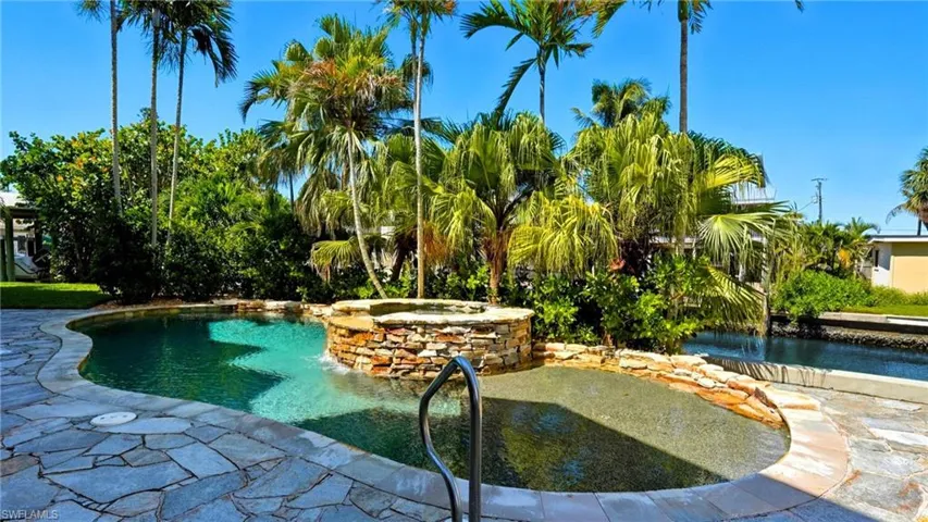 View of pool with a patio area and a pool with connected hot tub - Virtually Edited Image
