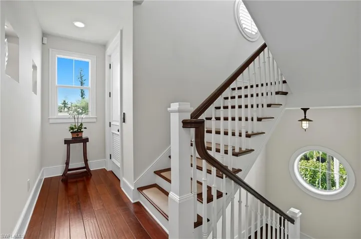 Stairs with hardwood / wood-style flooring and baseboards - Virtually Edited Image