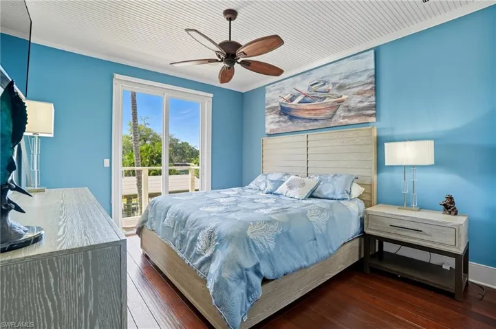Bedroom with crown molding, hardwood / wood-style floors, access to exterior, and a ceiling fan - Virtually Edited Image
