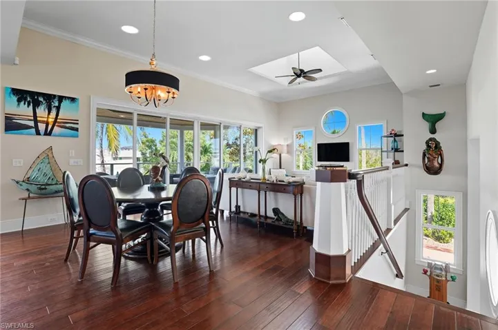 Dining space featuring ornamental molding, plenty of natural light, recessed lighting, a chandelier, and dark wood-type flooring - Virtually Edited Image