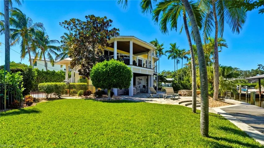 Rear view of house featuring a patio, a balcony, and a water view - Virtually Edited Image