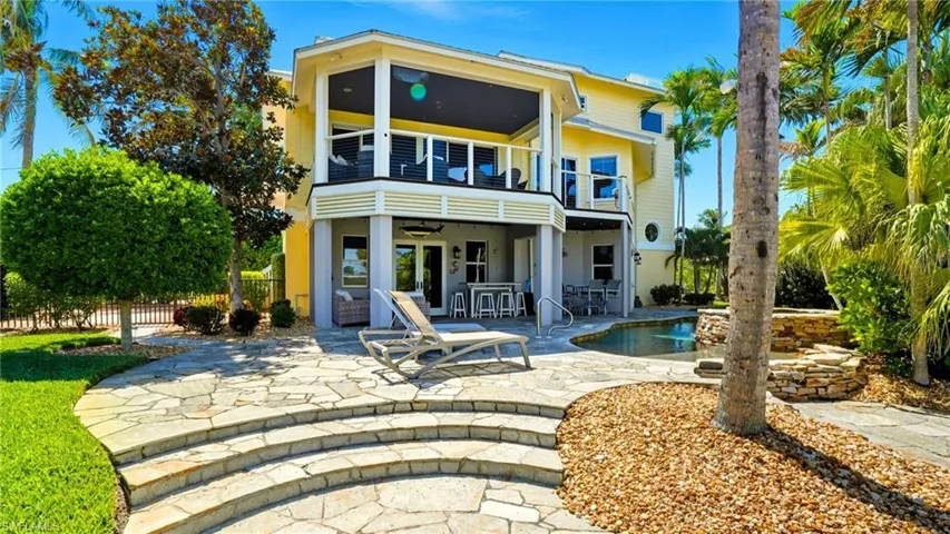 Back of house with a patio, ceiling fan, and a balcony - Virtually Edited Image