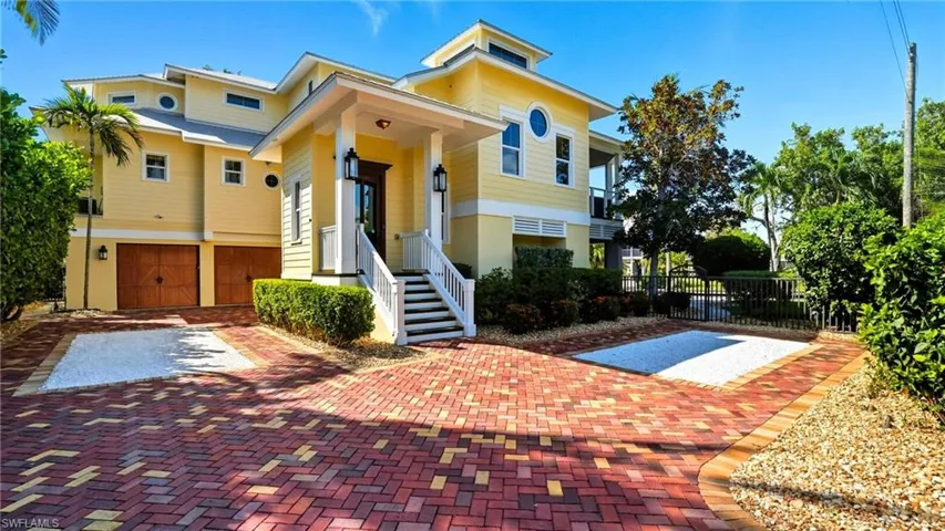 View of front facade with an attached garage and decorative driveway - Virtually Edited Image
