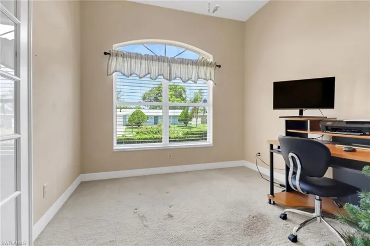 Carpeted home office featuring plenty of natural light
