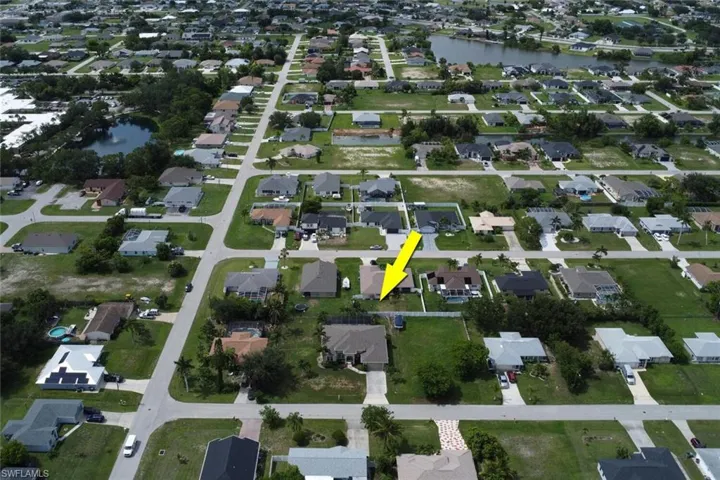 Aerial view of property and surrounding area with nearby suburban area and a large body of water