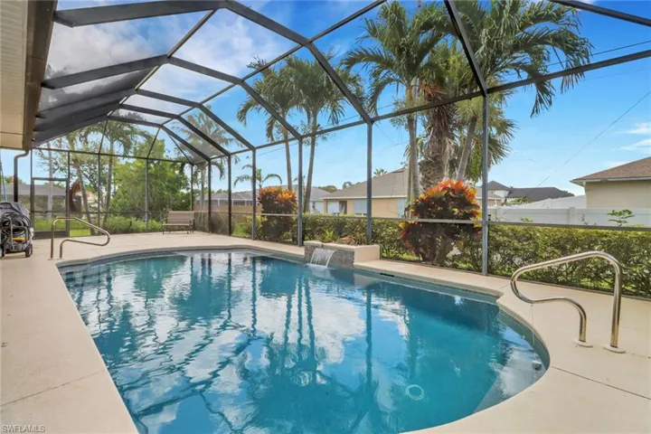 Outdoor pool with a patio area and glass enclosure