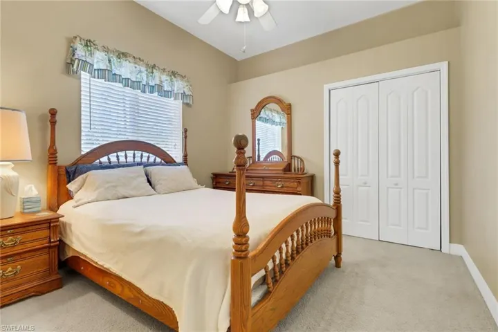 Bedroom featuring a closet, light colored carpet, and a ceiling fan