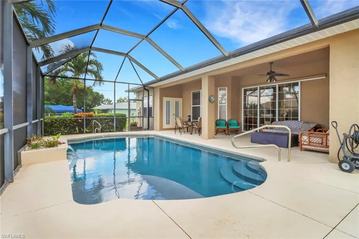 Swimming pool with a patio area, ceiling fan, glass enclosure, and an outdoor living space