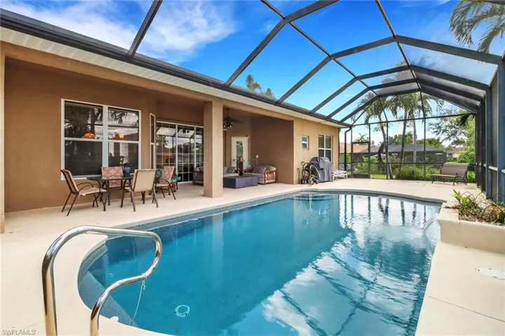 Swimming pool with a patio, ceiling fan, and glass enclosure