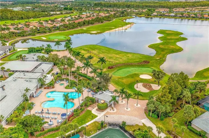 Aerial view of residential area featuring a nearby body of water and a golf club