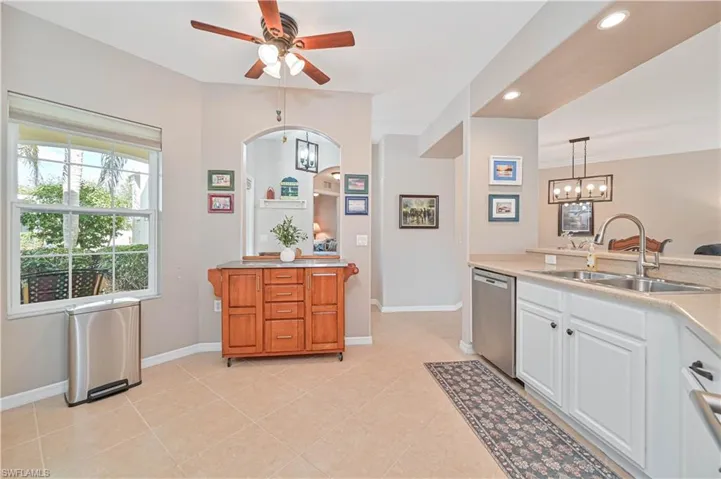 Kitchen with decorative light fixtures, white cabinets, stainless steel dishwasher, ceiling fan, and recessed lighting