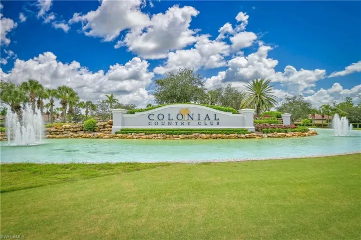 Community / neighborhood sign with a lawn and a water view