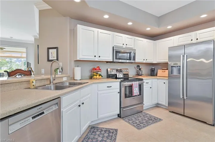 Kitchen featuring stainless steel appliances, white cabinets, recessed lighting, and light tile patterned floors