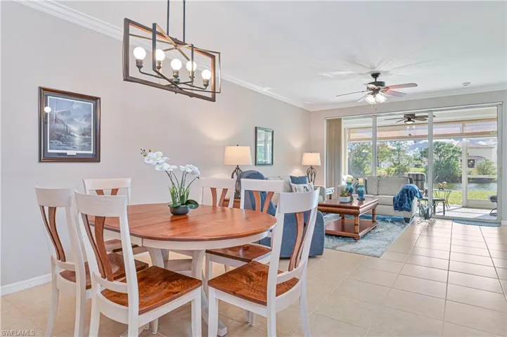 Dining room featuring ornamental molding, light tile patterned flooring, and a ceiling fan