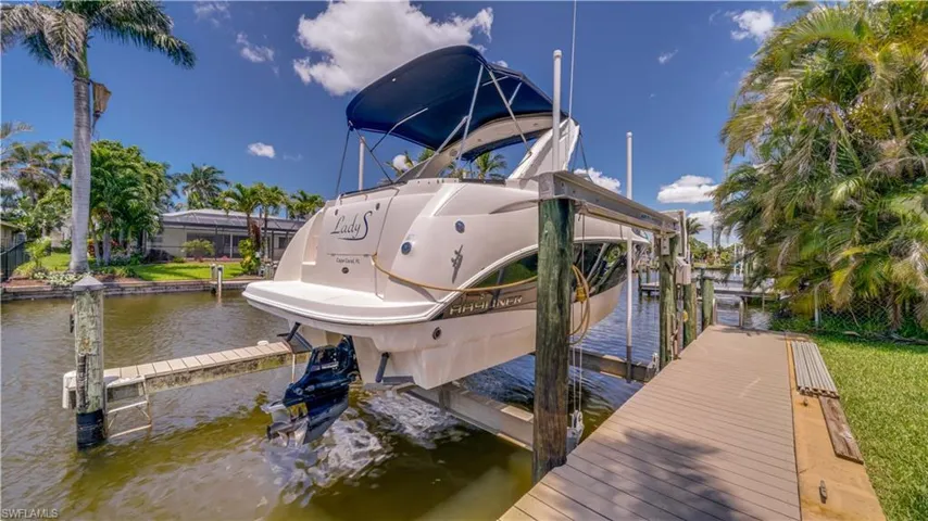 Dock area featuring boat lift with newer cradle.