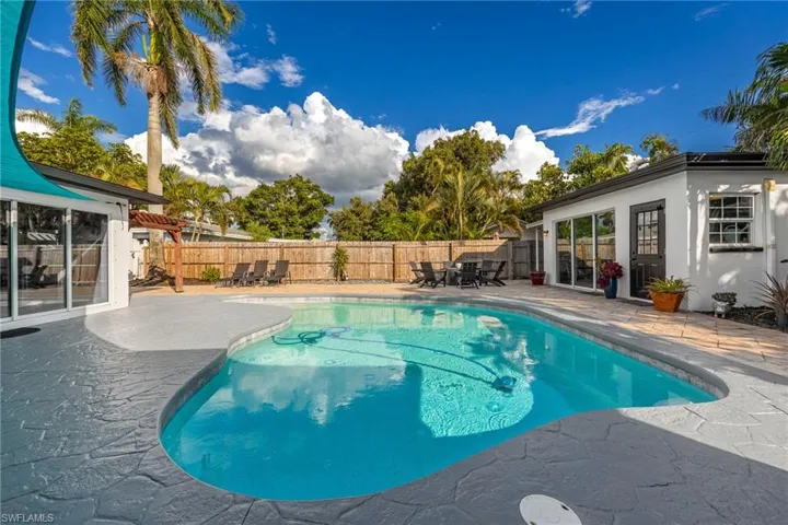 View of swimming pool with a patio, a fenced backyard, and outdoor dining area