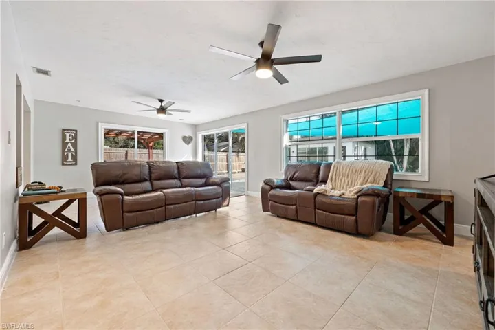 Living room with a ceiling fan and light tile patterned floors