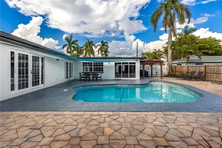 View of swimming pool featuring french doors, a patio, a pergola, and outdoor dining space