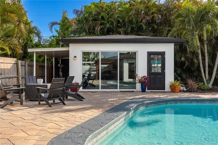 View of swimming pool featuring a patio, an outbuilding, and a storage structure