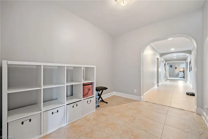 Hallway with light tile patterned floors and arched walkways