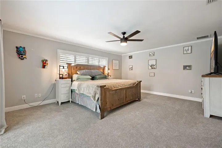 Bedroom featuring crown molding, light carpet, and ceiling fan
