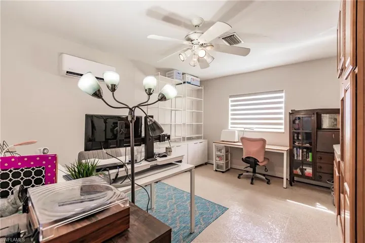 Office featuring a wall mounted AC and ceiling fan
